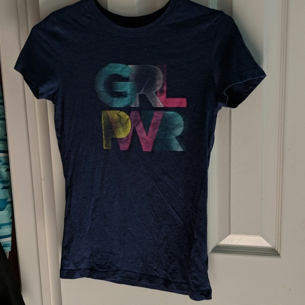 A purple t-shirt saying girl power abbreviated!